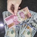 Ilustrasi: Petugas menghitung uang dolar AS dan uang rupiah di salah satu kantor cabang sebuah bank di Jakarta. (ANTARA FOTO/Reno Esnir/foc.)-1669866621