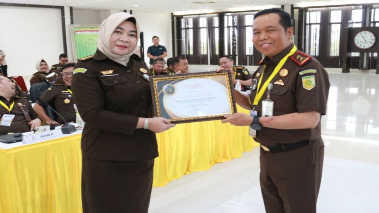 Kepala Kejaksaan Tinggi Kalimantan Barat Masyudi memberikan penghargaan kepada jajarannya saat penutupan rapat kerja daerah Kejaksaan Tinggi Kalimantan Barat, di Pontianak, Rabu (21/12/2022). ANTARA/HO-Penkum Kejati Kalbar.