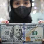 Pekerja menunjukkan uang dolar AS di salah satu gerai penukaran mata uang di Jakarta, Rabu (5/1/2022). ANTARA FOTO/Dhemas Reviyanto/wsj.-1669951016