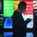 Seorang pria melintasi layar digital pergerakan saham di Bursa Efek Indonesia, Jakarta, Jumat (24/6/2022). ANTARA FOTO/Akbar Nugroho Gumay/foc.-1670221706
