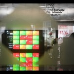 Seorang pria melintasi layar digital pergerakan saham di Bursa Efek Indonesia, Jakarta, Jumat (24/6/2022). ANTARA FOTO/Akbar Nugroho Gumay/foc/aa.-1671590038