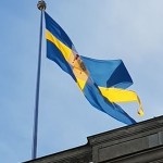 Bendera Swedia berkibar di atas Istana Kerajaan di Stockholm. (Wikimedia/GreatesMoom)-1674537423