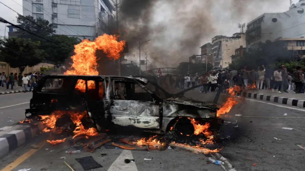 Massa membakar kendaraan di jalan saat aksi unjuk rasa memprotes praktik korupsi dan pembatasan internet atau larangan menggunakan media sosial/Foto: Aljazeera