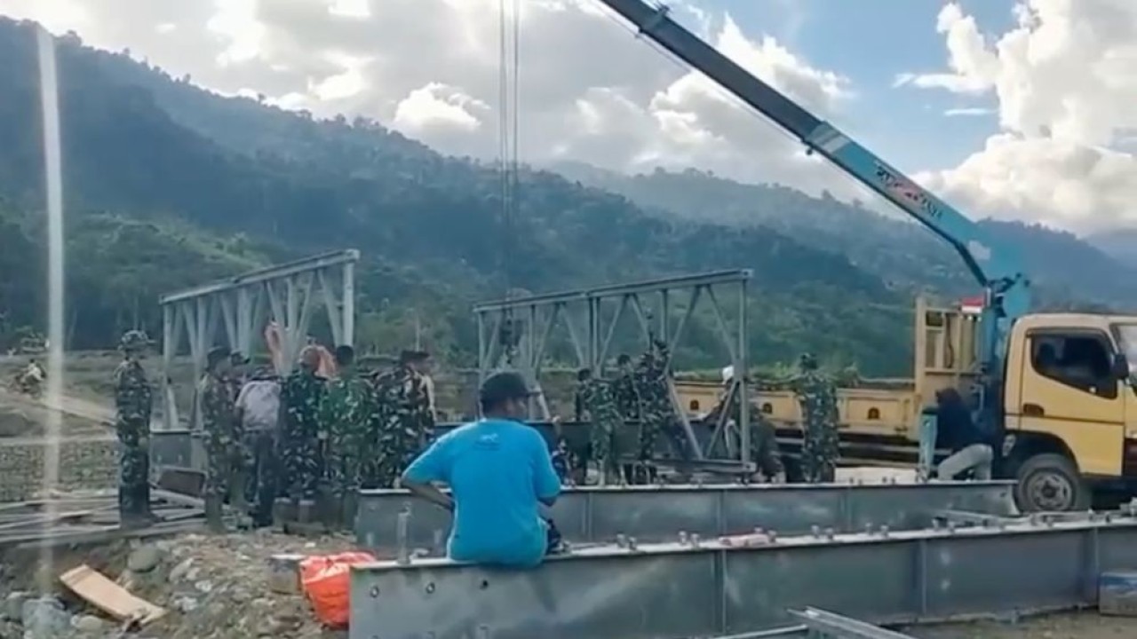 Pasukan TNI bersama petugas lapangan tengah merakit komponen jembatan, seperti panel rangka baja dan girder baja. (Foto: Istimewa)